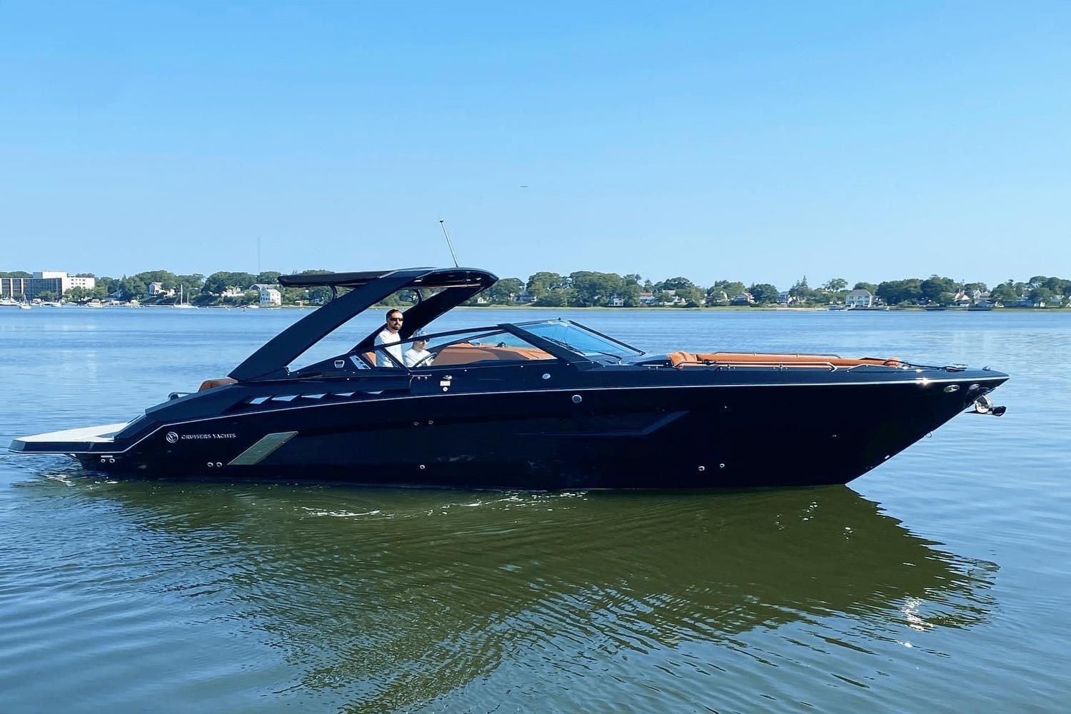 Cruisers Yachts 338 CX 2021 Cruisers Yachts 338 CX on calm water with a clear blue sky.