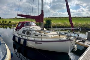 Midget 26 Sailboat Midget 26, 2006 model, docked on a calm waterway under a cloudy sky.