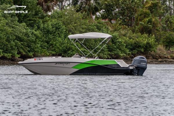 Starcraft SVX 231 OB DH 2023 Starcraft SVX 231 OB DH boat on water with lush greenery background.