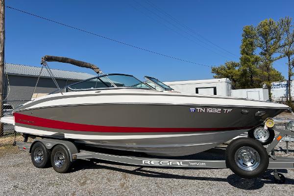 Regal 2500 Bowrider 2012 Regal 2500 Bowrider boat on trailer, gray and red design, parked outdoors.