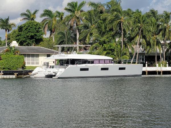 Lagoon Motor Yacht 2015 Lagoon Motor Yacht docked by palm trees and waterfront homes.