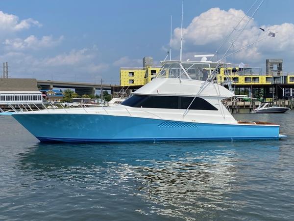 Viking 55 Convertible 1999 Viking 55 Convertible yacht on calm water, blue hull, marina background.