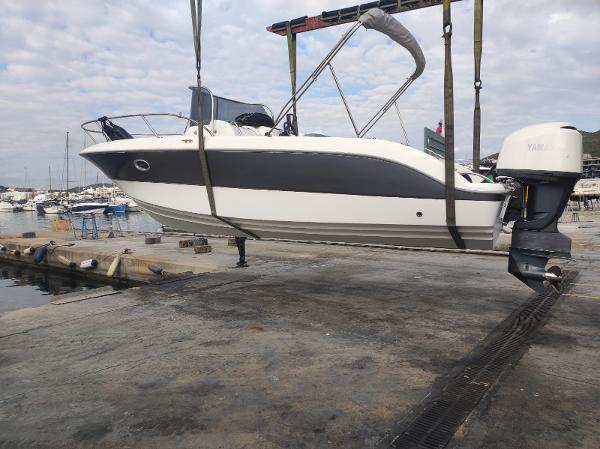 Sessa Marine Key Largo 25 2023 Sessa Marine Key Largo 25 boat lifted at a marina, showcasing sleek design.