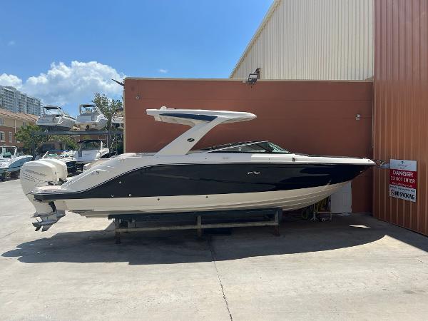 Sea Ray SLX 310 Outboard 2021 Sea Ray SLX 310 OB boat docked near a warehouse.