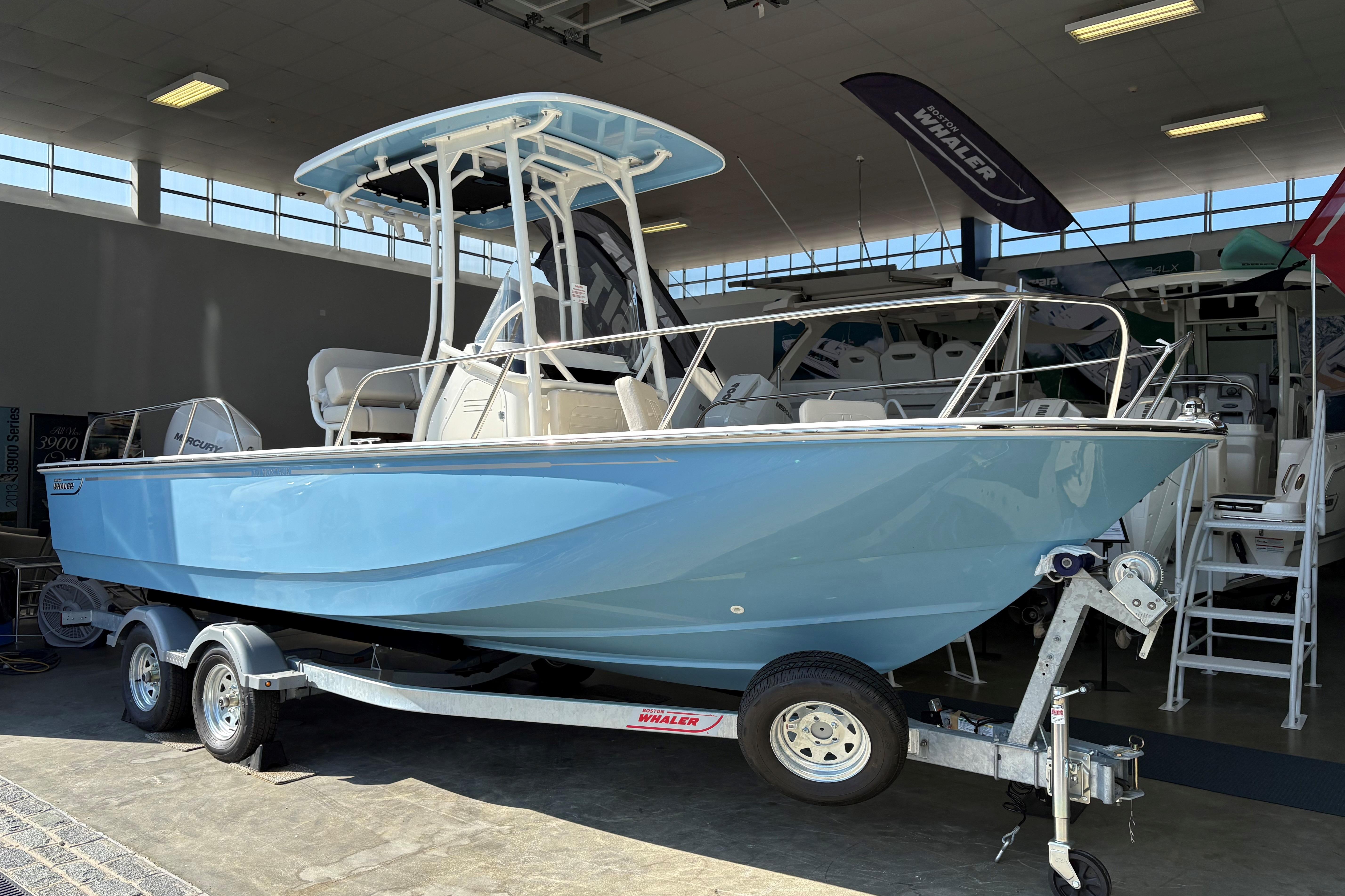 Boston Whaler 210 Montauk 2026 Boston Whaler 210 Montauk boat in showroom, light blue hull, on a trailer.