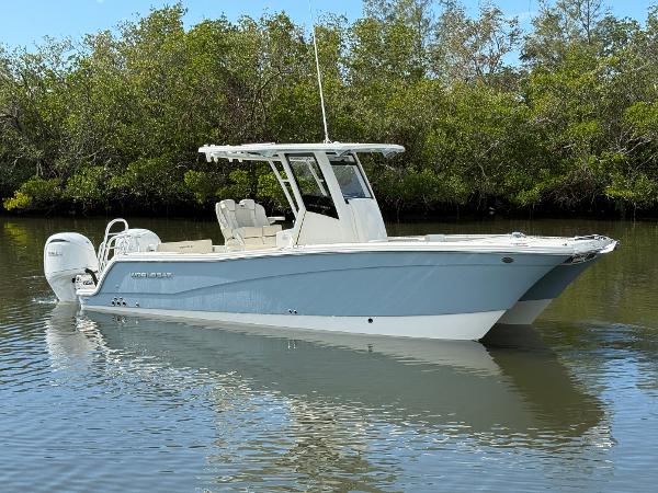 World Cat 260 CC-X 2025 World Cat 260 CC-X boat on calm water, surrounded by lush greenery.