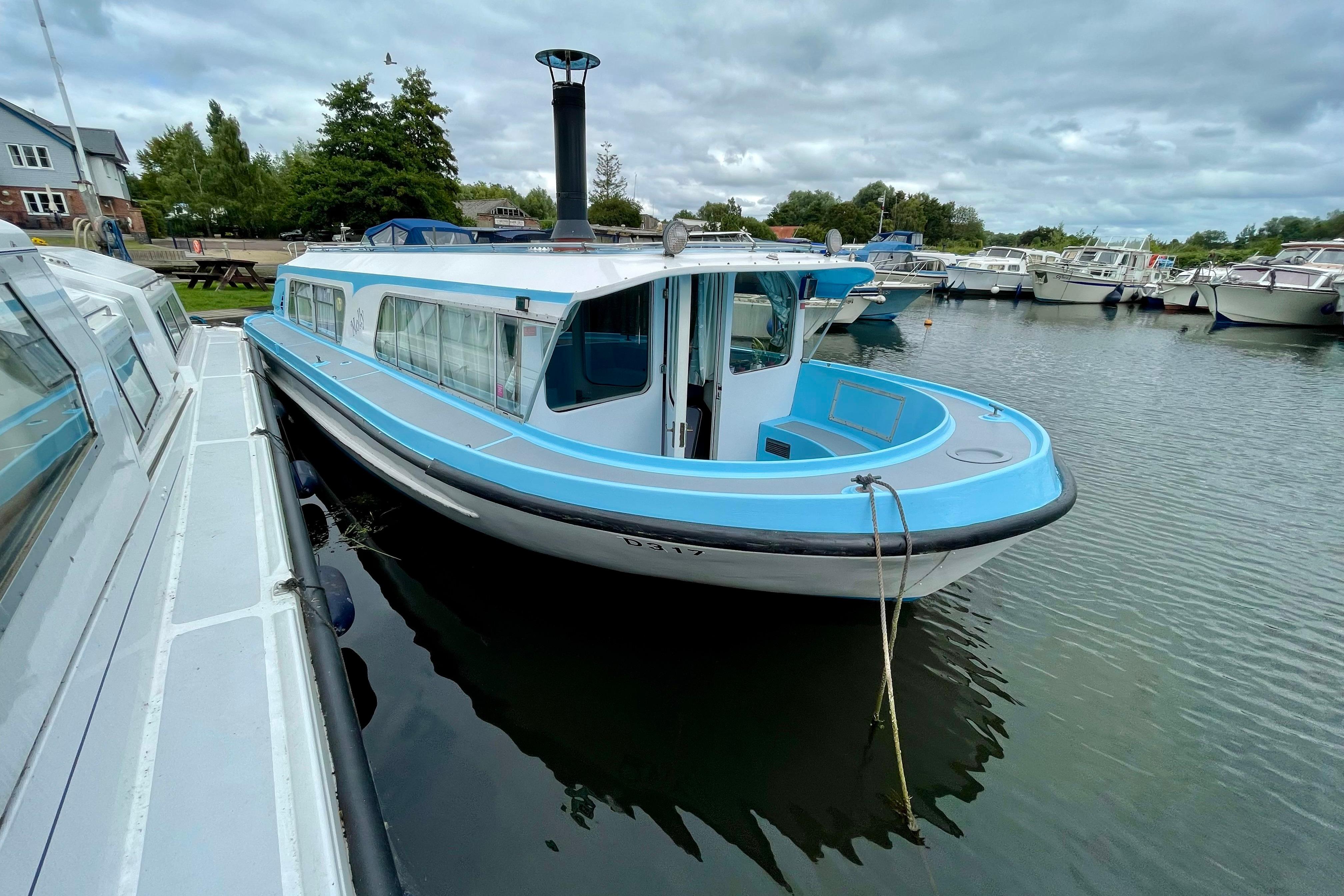 Custom Bermuda 34 1970 Bermuda 34 boat docked in a marina, featuring a blue and white exterior.