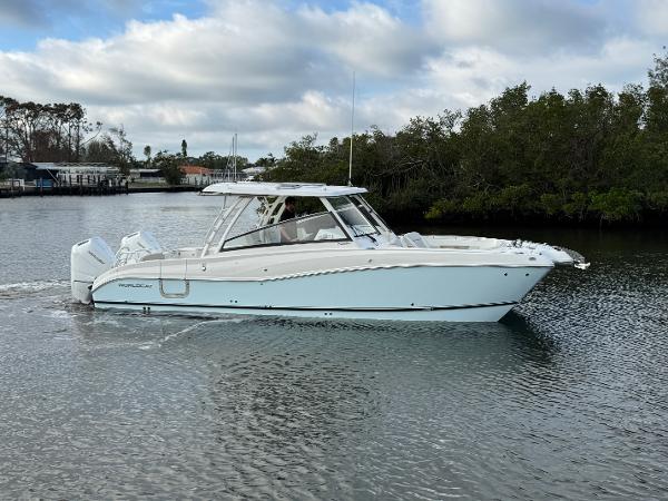 World Cat 325 DC 2025 World Cat 325 DC boat cruising on a calm river.
