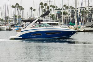 Regal 32 Express 2014 Regal 32 Express boat cruising in a marina with sailboats in the background.