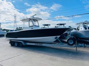Sea Hunt Gamefish 27 Coffin Box 2019 Sea Hunt Gamefish 27 boat on trailer, parked outdoors under blue sky.