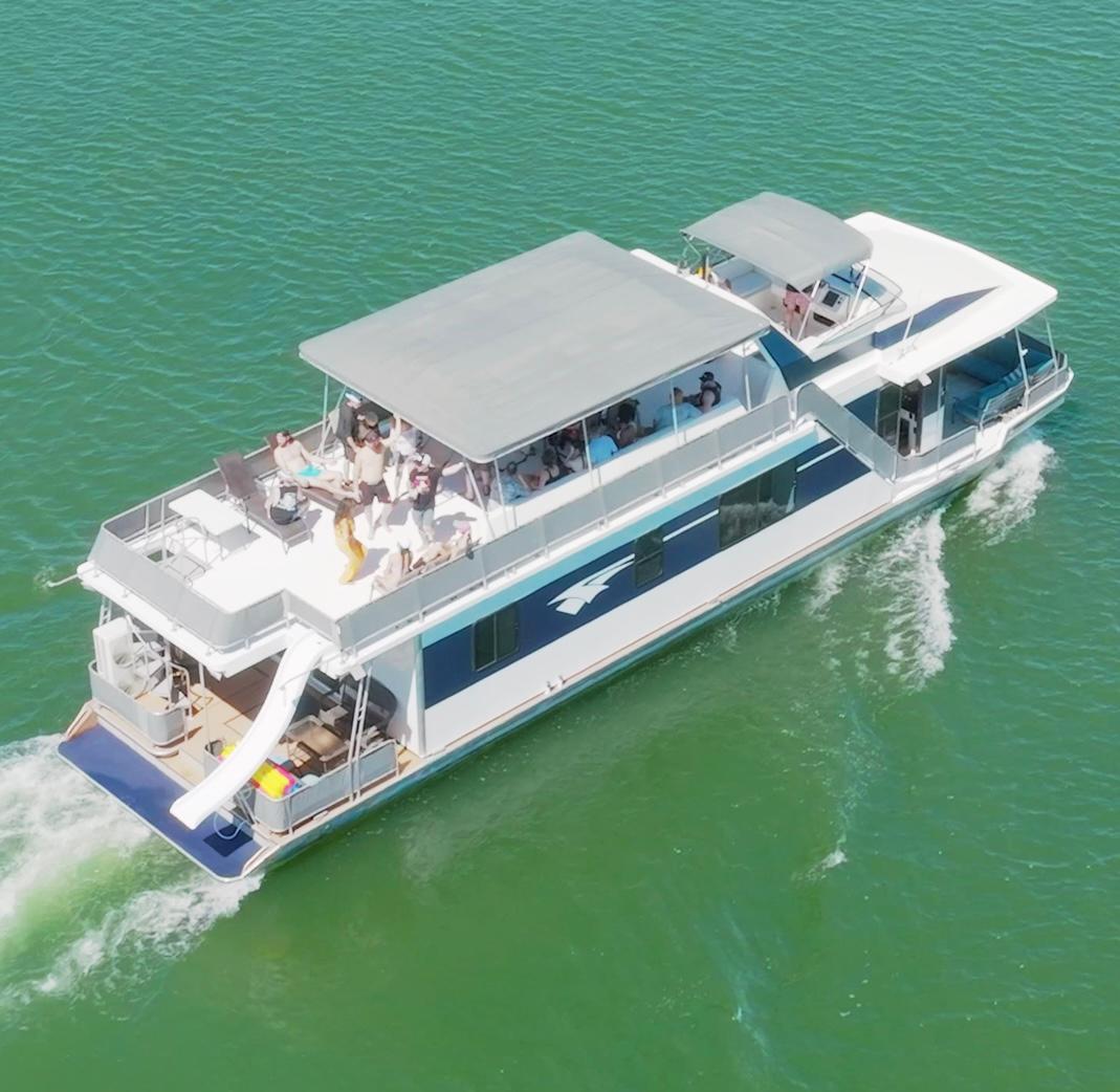 Stardust Cruisers Houseboat 1994 Stardust Cruisers houseboat on water, featuring upper deck with people enjoying the sun.