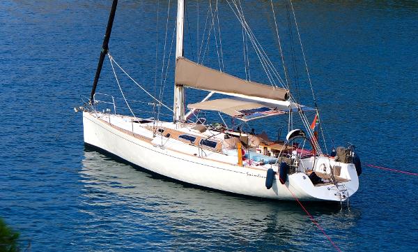 Custom Schumacher 41 Sailboat "Schumacher 41" from 1989 on calm blue water, featuring sleek design and white hull.