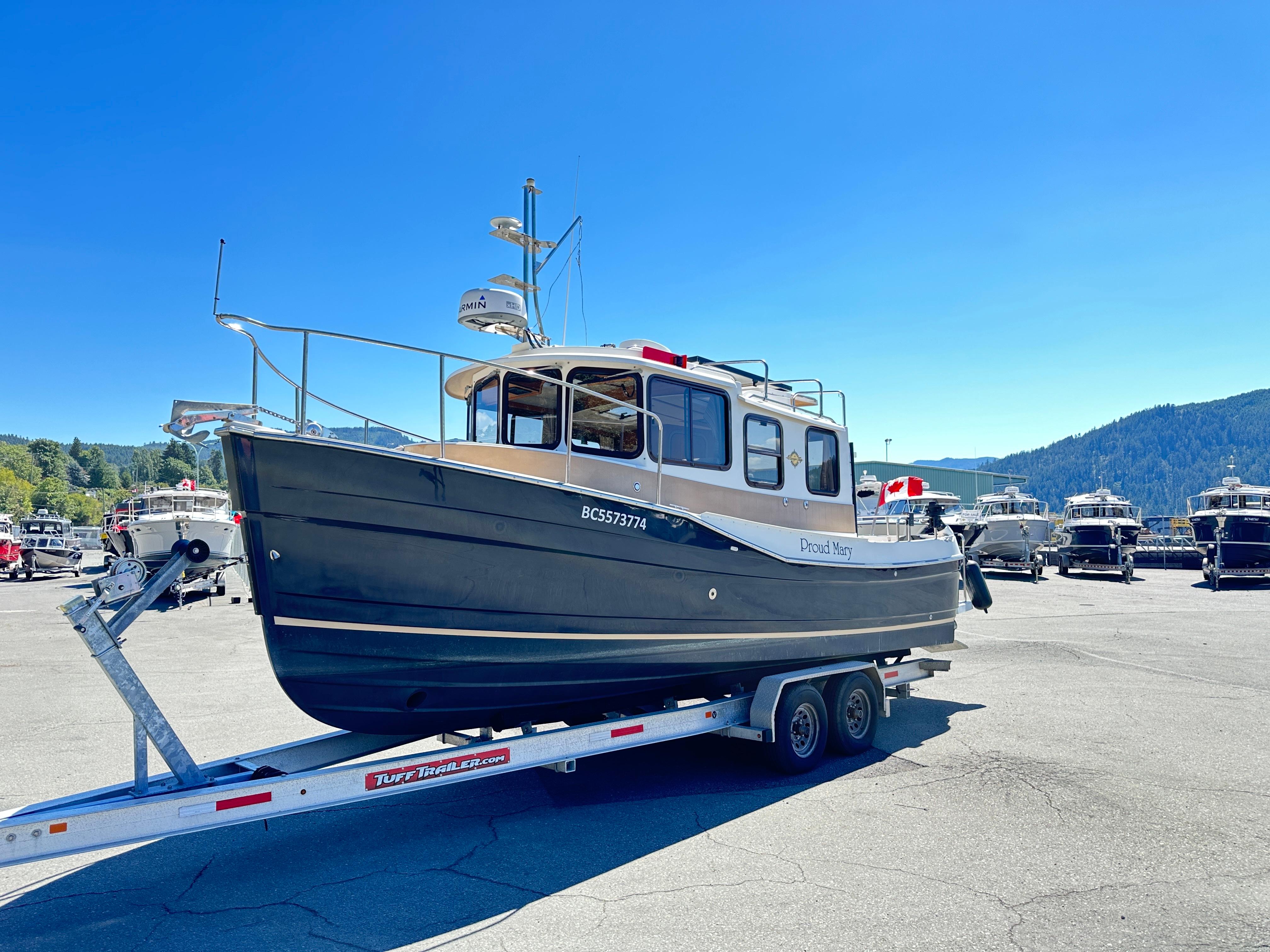 Ranger Tugs R-25 SC 2017 Ranger Tugs R-25 SC boat on trailer in sunny marina setting.