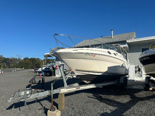 Sea Ray 260 Sundancer 2003 Sea Ray 260 Sundancer boat on trailer, parked outdoors under clear blue sky.