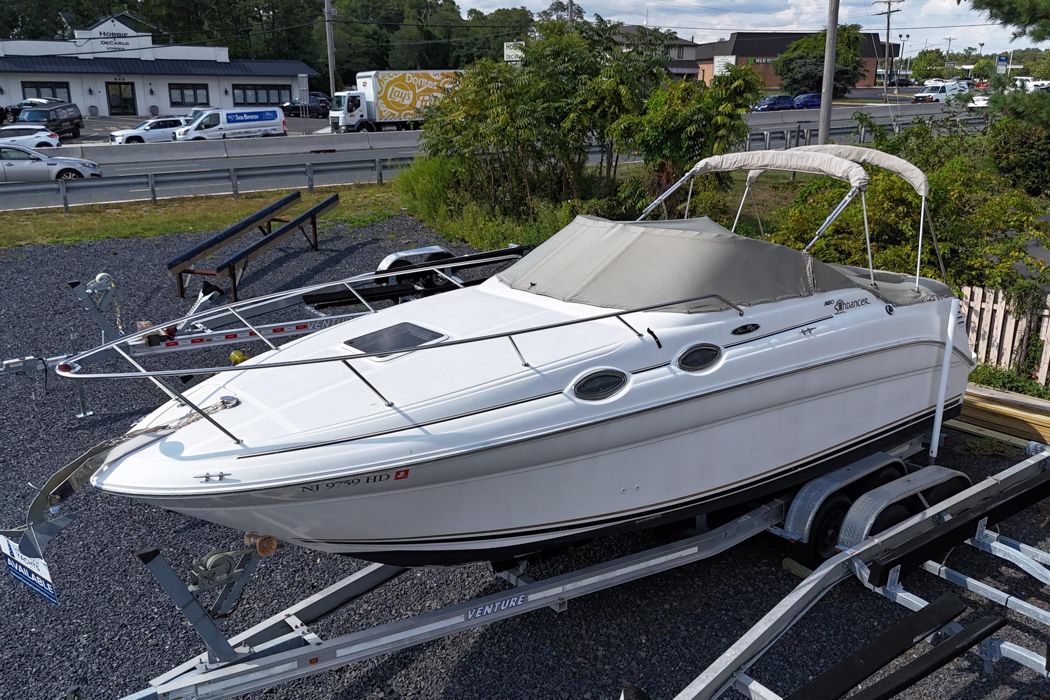 Sea Ray 260 Sundancer 2003 Sea Ray 260 Sundancer boat on trailer, parked near a road.