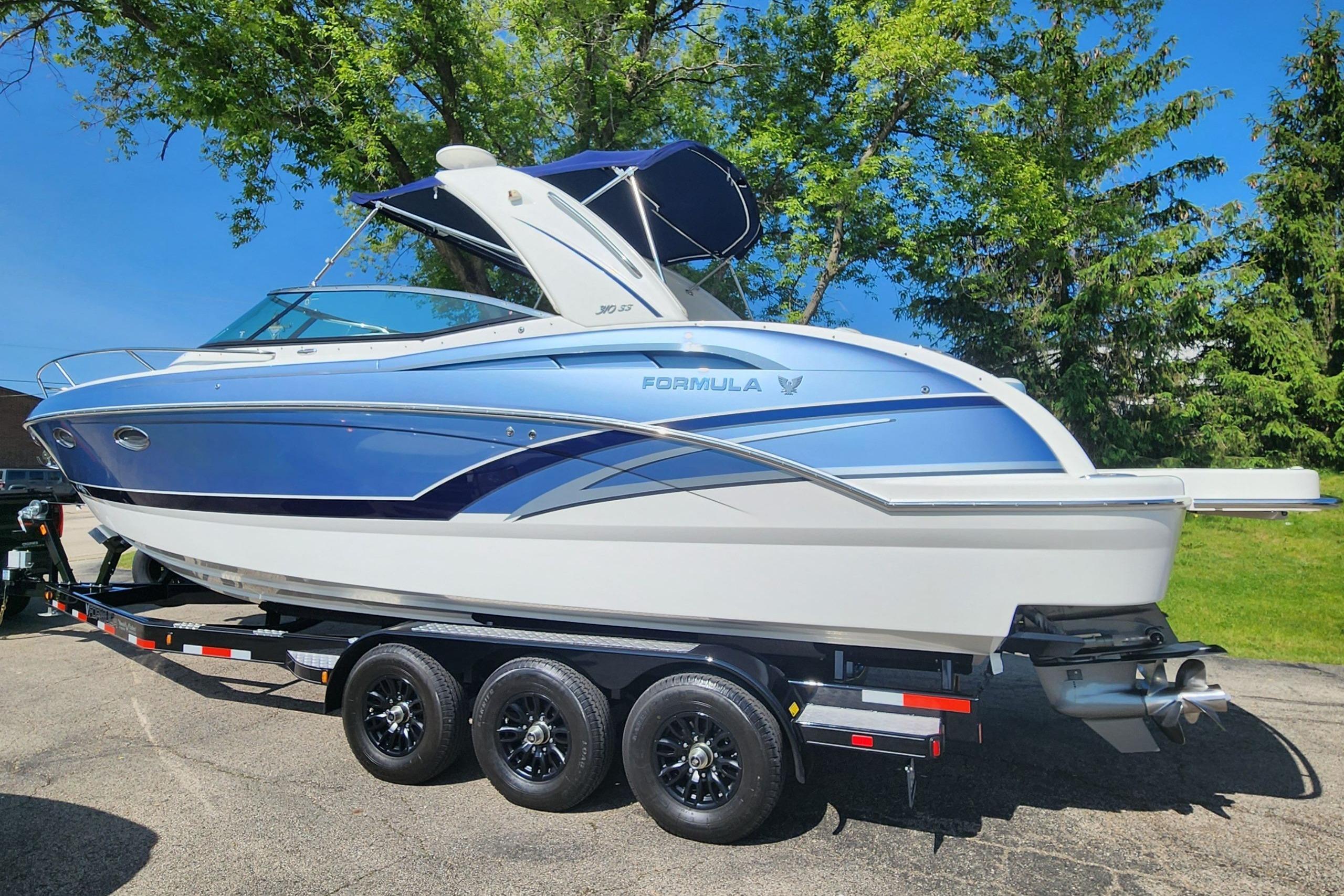 Formula 310 Sun Sport 2018 Formula 310 Sun Sport boat on trailer, blue and white design, parked outdoors.