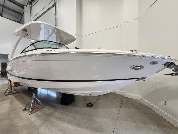 Regal LS6 2025 Regal LS6 boat in showroom, sleek white design, elevated on stands.