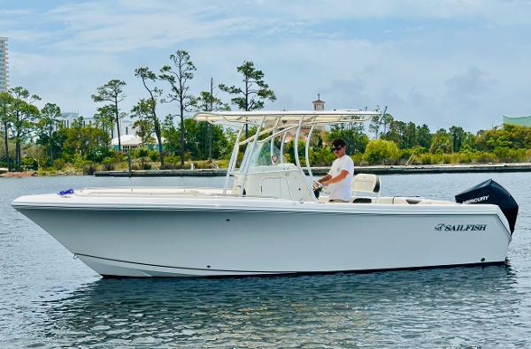 Sailfish 242 CC 2022 Sailfish 242 CC boat on calm water with trees in the background.