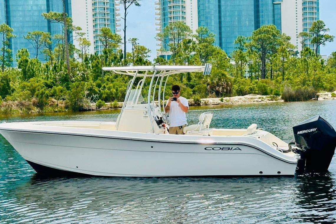 Cobia 237 Center Console 2022 Cobia 237 Center Console boat on water with scenic background.
