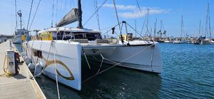 Nautitech 44 Open 2023 Nautitech 44 Open catamaran docked at a marina under a clear blue sky.