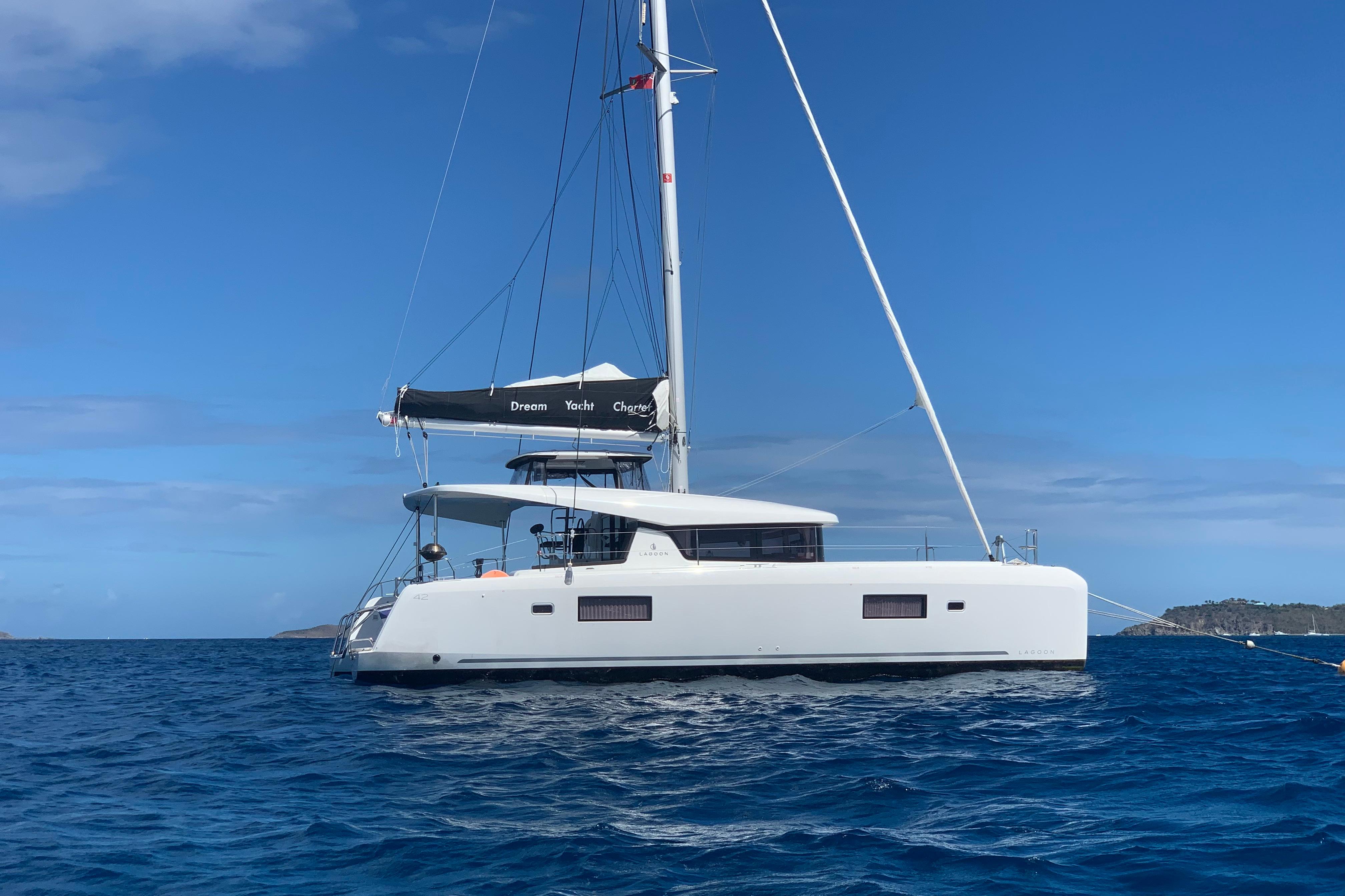 Lagoon 42 2019 Lagoon 42 catamaran sailing on blue ocean under clear sky.