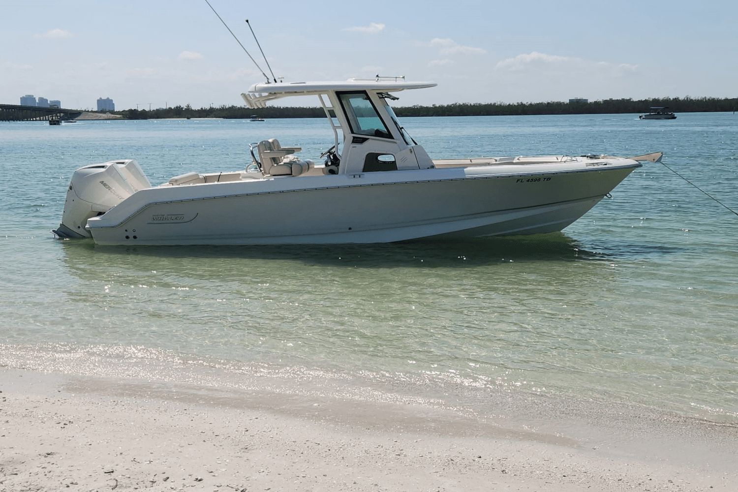 Boston Whaler 250 Outrage 2022 Boston Whaler 250 Outrage boat anchored on a sandy beach.