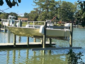 Custom 24 Custom 24 boat on lift at dock, surrounded by trees and calm water, 2022 model.
