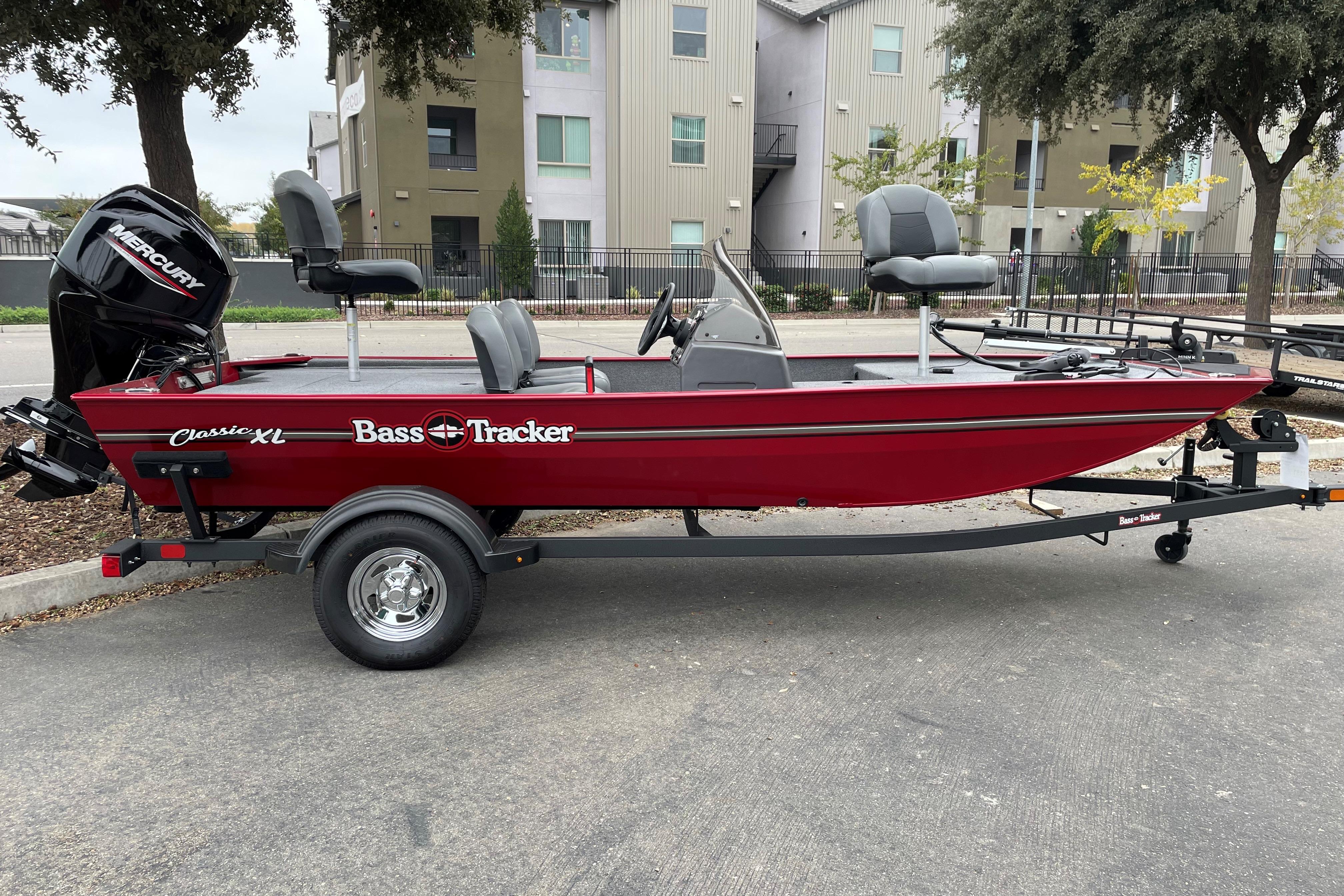 Tracker Bass Tracker Classic XL 2025 Tracker Bass Tracker Classic XL boat, red, parked on trailer, outdoor setting.