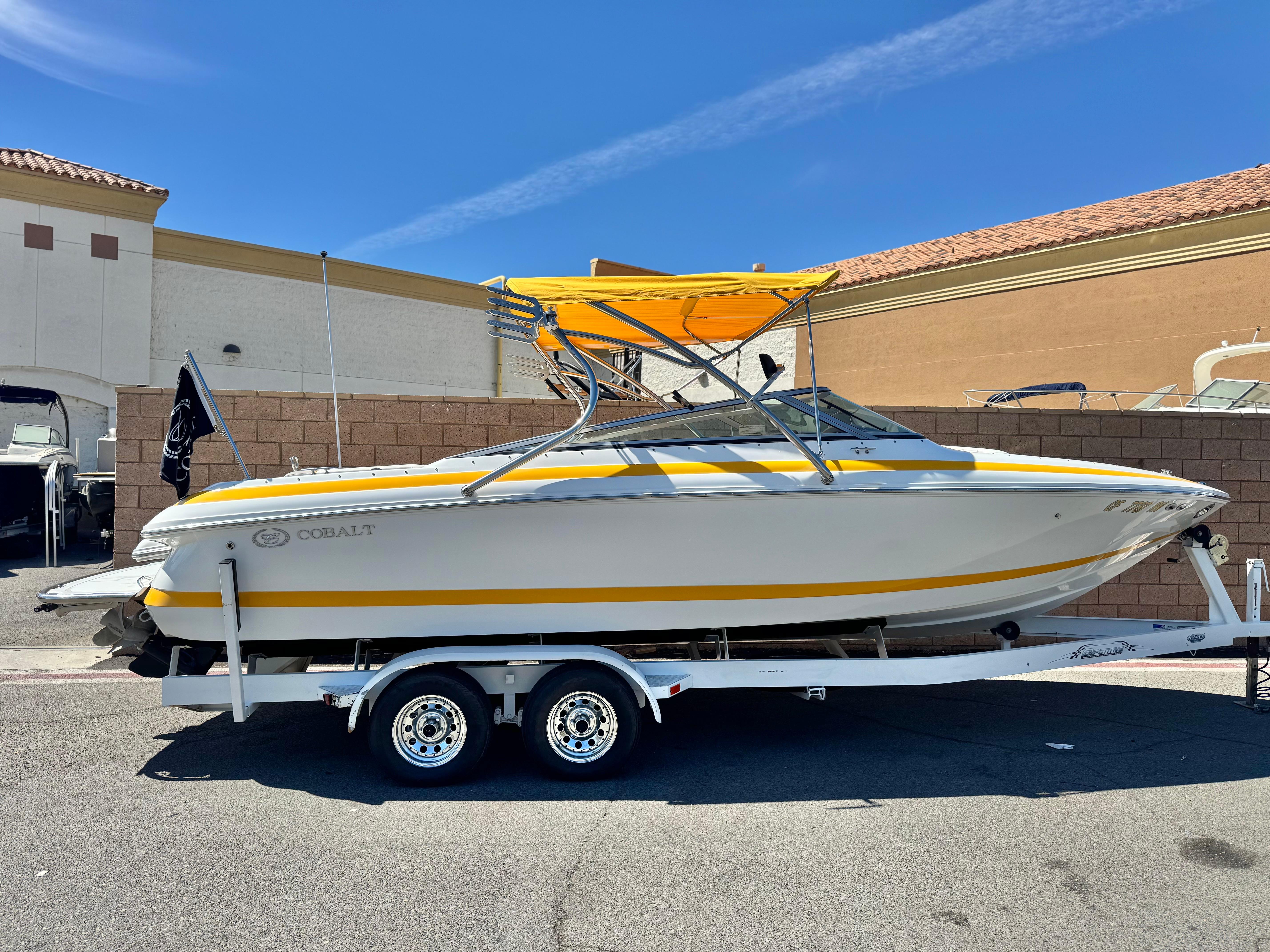Cobalt 246 2006 Cobalt 246 boat with yellow accents on a trailer, parked outdoors.