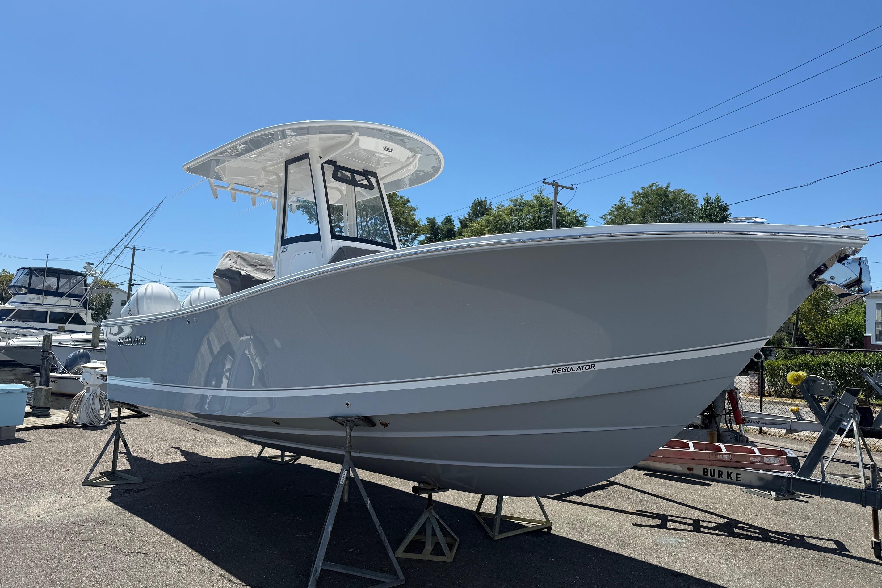 Regulator 25 2026 Regulator 25 boat on stands, displayed outdoors under clear blue sky.