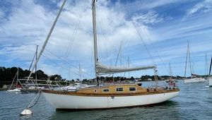 Custom chassiron 9 CF 1979 Custom Chassiron 9 CF sailboat on calm water under a blue sky.