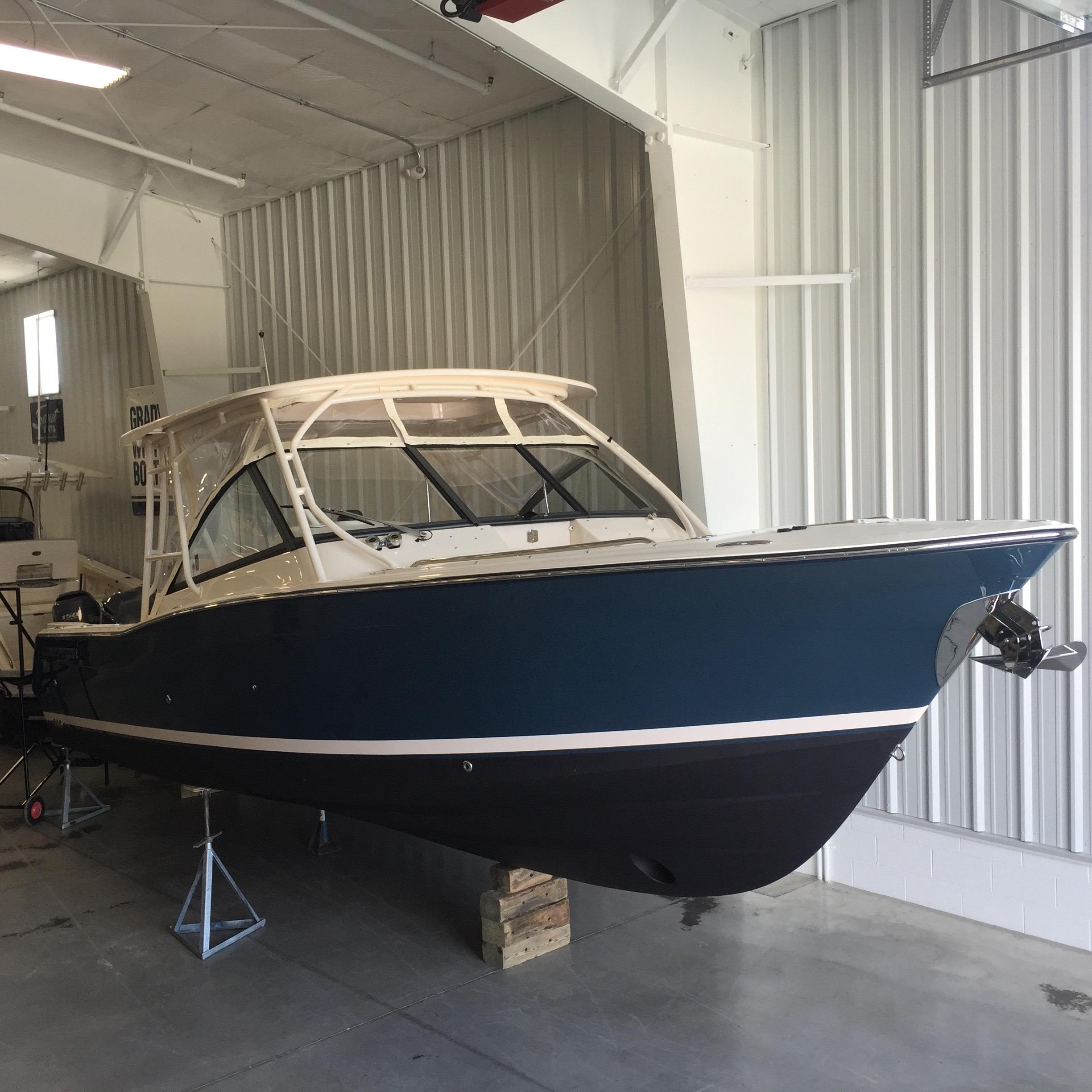 Grady-White Freedom 307 2016 Grady-White Freedom 307 boat in storage, blue hull, indoor facility.