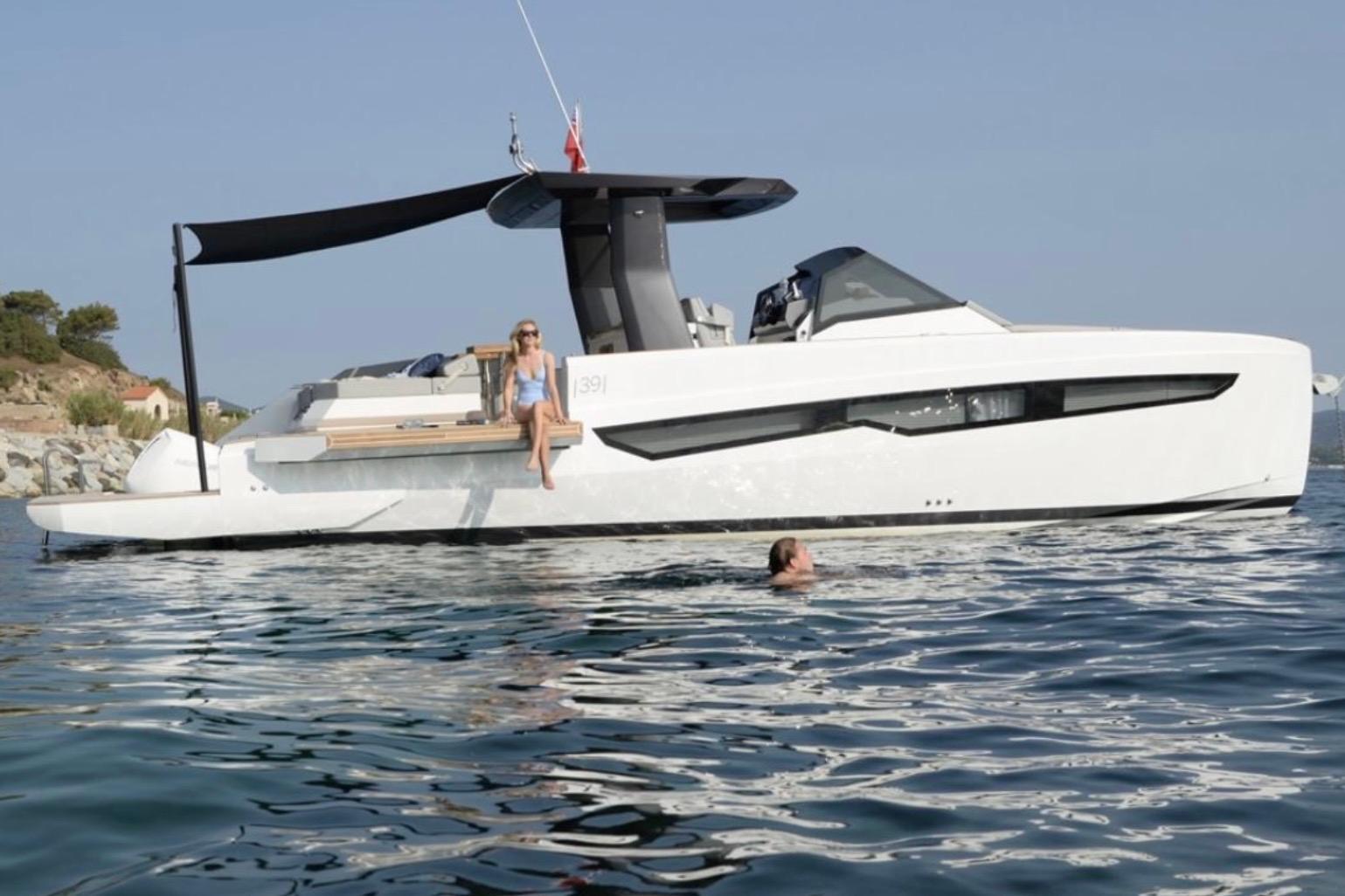Fiart Seawalker 39 2022 Fiart Seawalker 39 yacht on water, with person relaxing onboard and another swimming nearby.