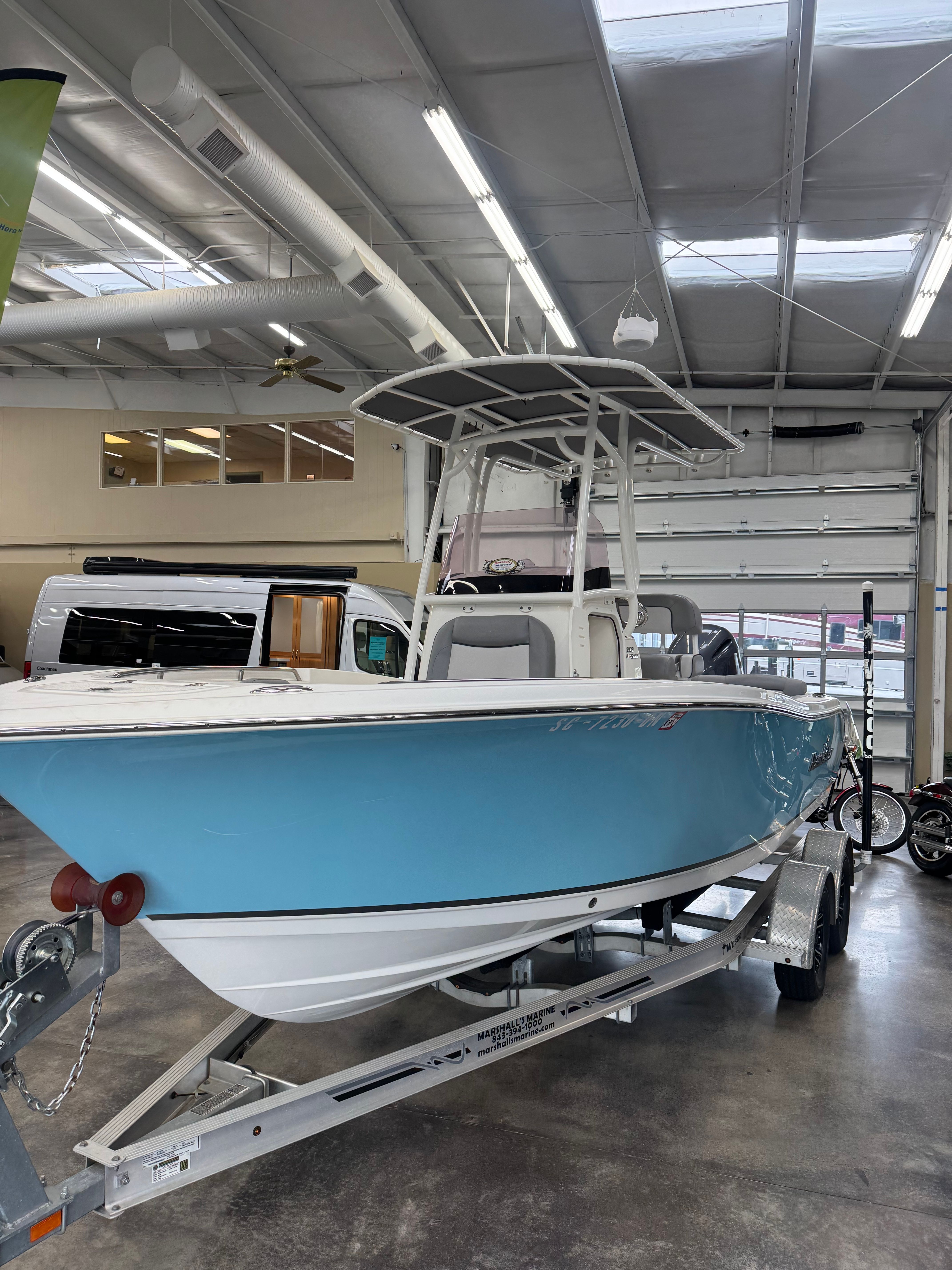 NauticStar 2102 Legacy 2021 NauticStar 2102 Legacy boat in showroom, blue hull, on trailer.