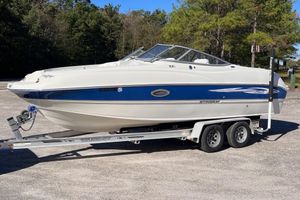 Stingray 22DR 2007 Stingray 22DR boat on trailer, parked outdoors with trees in background.