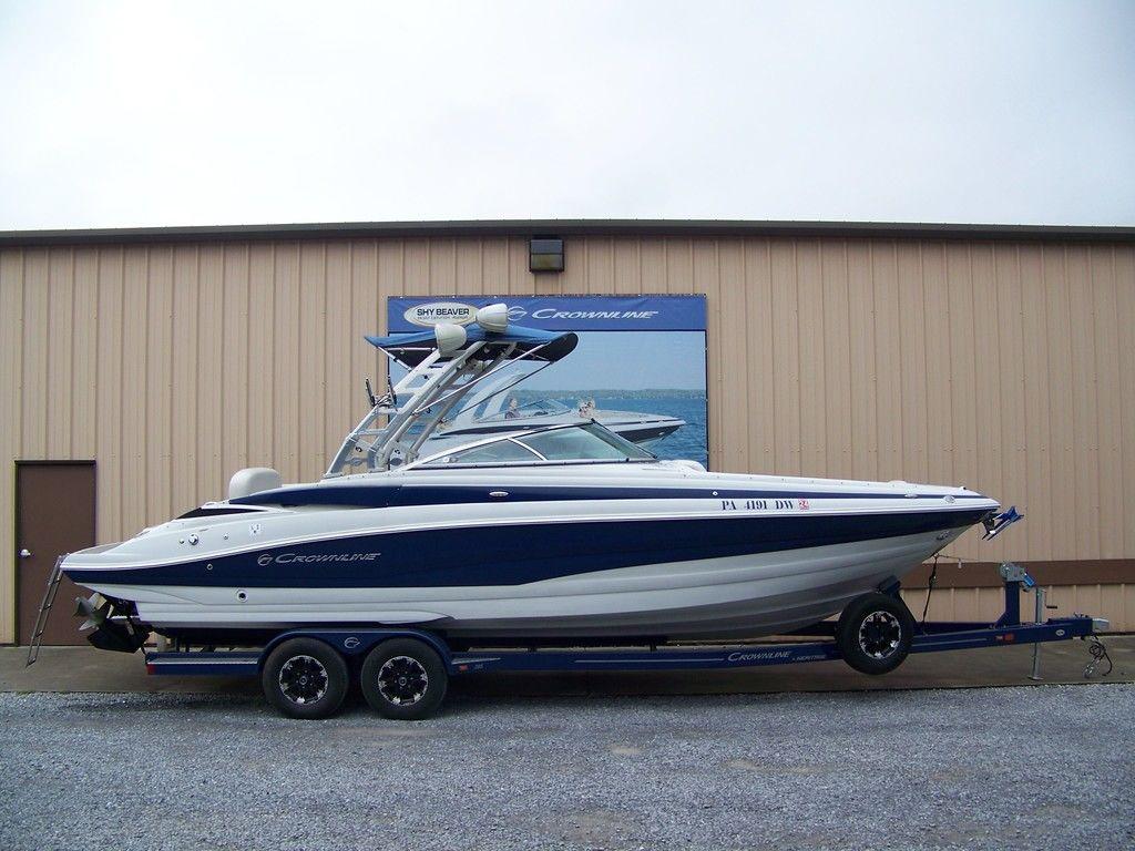 Crownline 285 SS 2019 Crownline 285 SS boat on trailer, parked outside a beige building.
