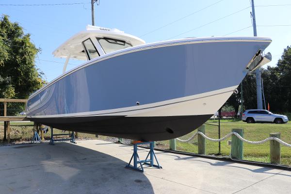 Pursuit S 328 Sport 2021 Pursuit S328 Sport boat on display, blue hull, outdoor setting.