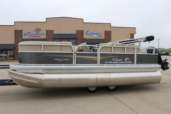 Sun Tracker Party Barge 18 DLX 2025 Sun Tracker Party Barge 18 DLX pontoon boat parked outside dealership.