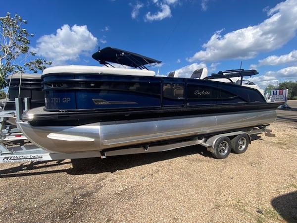 Barletta Corsa 23 UC 2023 Barletta Corsa 23 UC pontoon boat on a trailer under a blue sky.