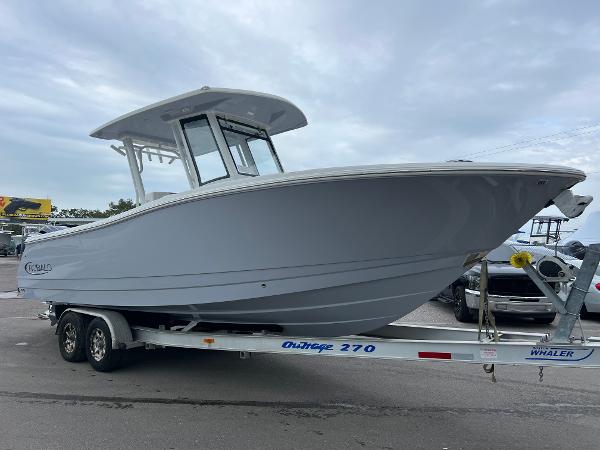 Robalo R270 Center Console 2024 Robalo R270 boat on trailer, parked outdoors under cloudy sky.