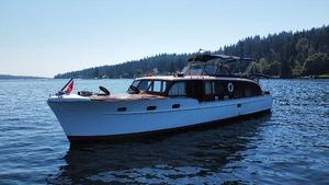 Chris-Craft 500 Constellation 1951 Chris-Craft Catalina boat on a serene lake with forested shoreline.