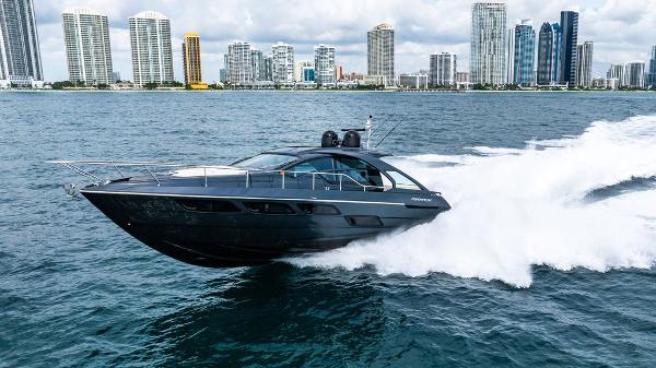Pershing 5x 2018 Pershing 5x yacht cruising fast on water with city skyline in background.