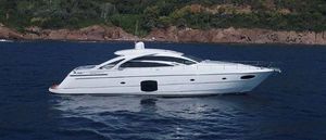 Pershing 70 Luxury 2015 Pershing 70 yacht cruising on serene blue waters near a rocky coastline.