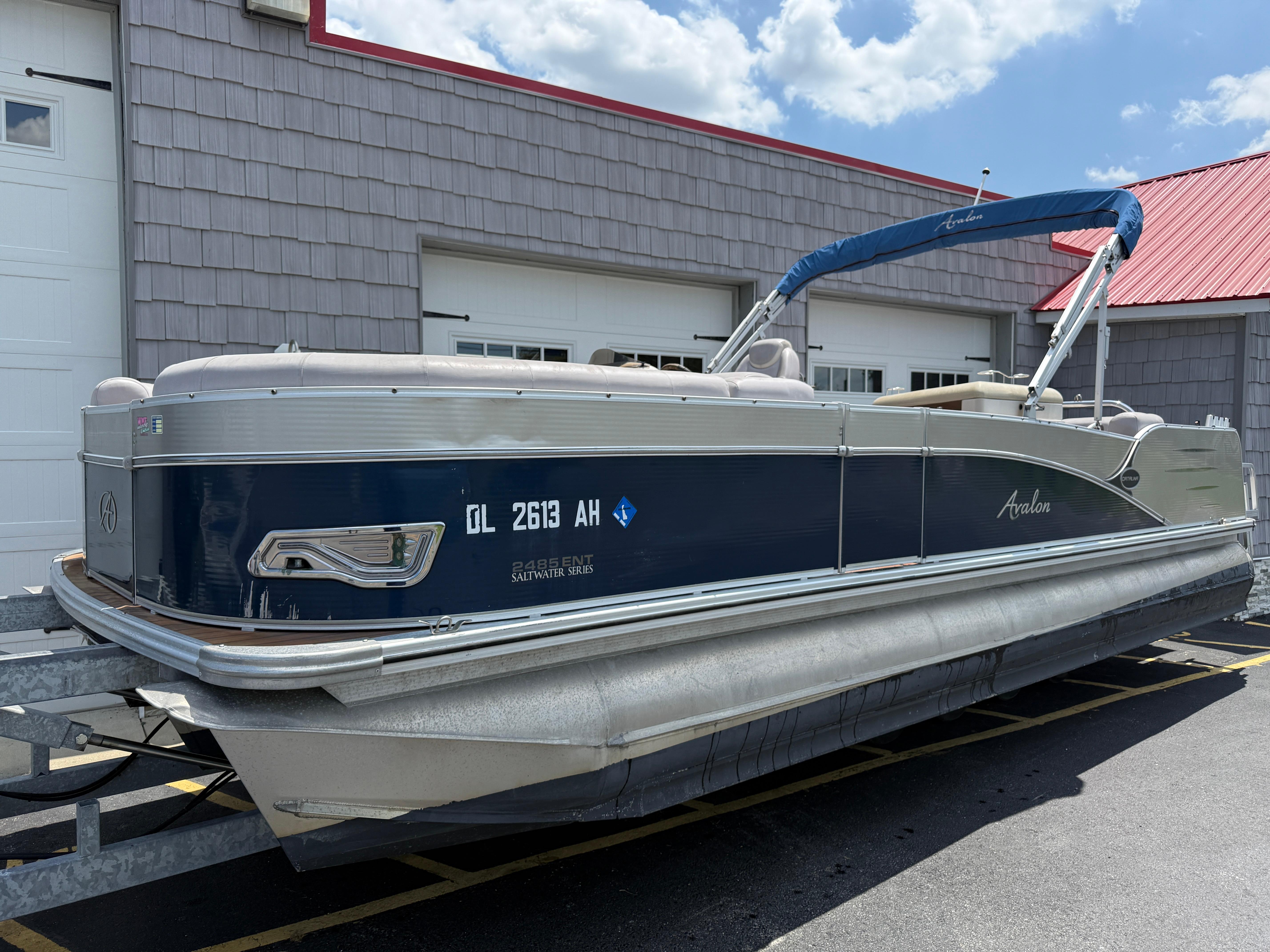 Avalon 2585 Catalina Bar / ENT Tri Toon High Performance 2014 Avalon 2585 Catalina Bar Tri Toon boat parked outside a building.