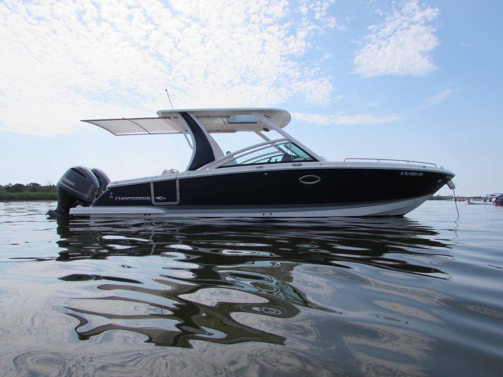 Chaparral 300 OSX 2020 Chaparral 300 OSX boat on calm water under a partly cloudy sky.
