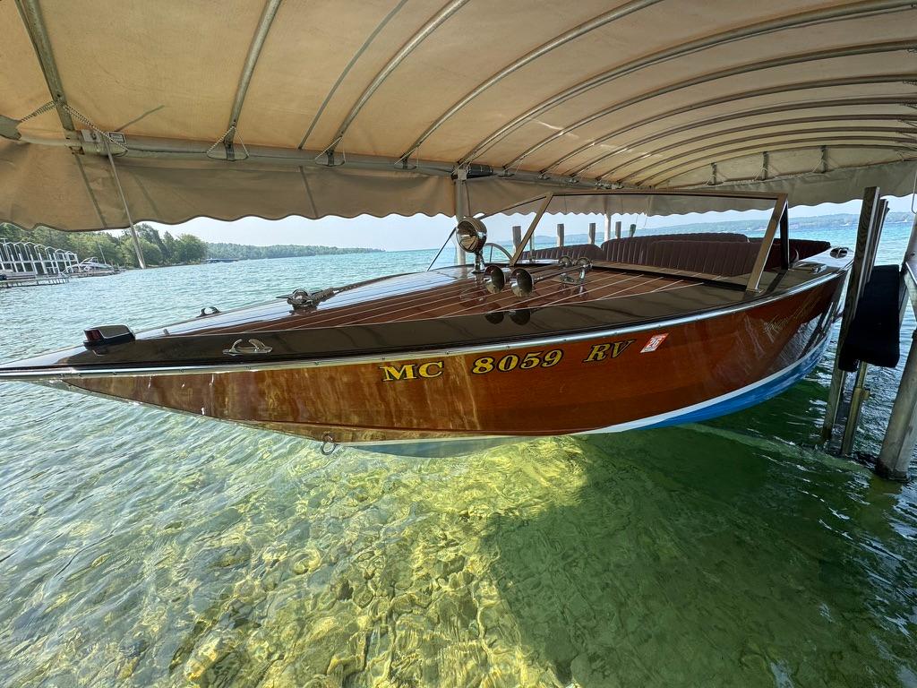 Grand Craft 21 RUNABOUT Classic 1999 Grand Craft 21 Runabout boat docked on clear water under a canopy.