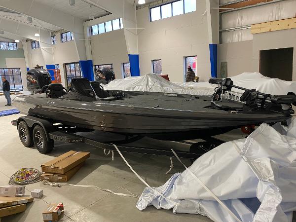 Skeeter ZXR21 2025 Skeeter ZXR21 boat in showroom, sleek design, dual motors, on trailer.