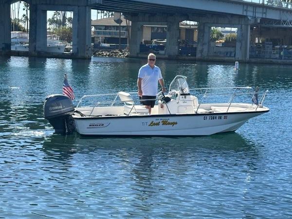 Boston Whaler 150 Montauk 2017 Boston Whaler 150 Montauk boat on water with person standing, bridge in background.