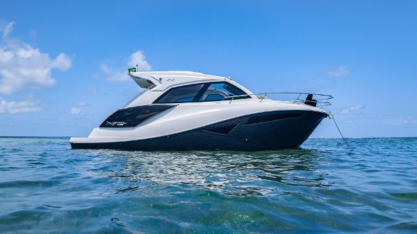 NX Boats NX 370 SPORT 2025 NX Boats NX370 Sport cruising on clear blue water under a sunny sky.