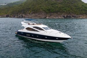Sunseeker Manhattan 60 2007 Sunseeker Manhattan 60 yacht cruising near a lush, rocky coastline.